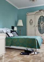 Bedroom with antique wardrobe and turquoise walls