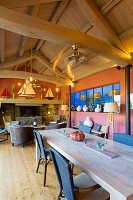 Dining area and lounge with colorful walls, wooden ceiling with exposed beams