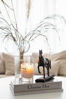 Coffee table with vase, books, candle, and horse figurine