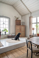 Platform with dog in front of corner cupboard in a converted chapel