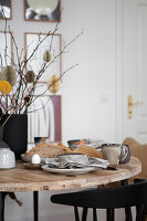 Easter breakfast table with vase of twigs decorated with paper eggs