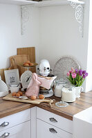 Food processor, scales, rabbit figure, glass vessels and tulips on the kitchen worksurface