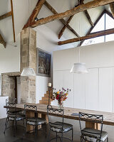 exposed beam ceiling over refectory style table in converted double-height barn