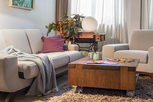 Pale upholstered sofa and coffee table wit h castors on a deep-pile rug in the living room