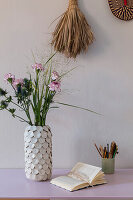Carnations in ceramic vase on desk