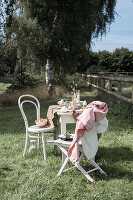 Ostertisch mit Leinetischdecke und Stühlen im Garten