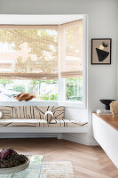 Black and white bench in the window bay of minimalist living room