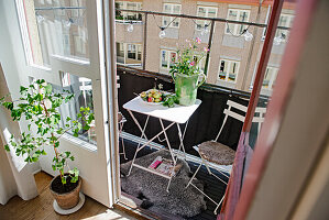 Kleiner Tisch mit Stühlen auf sommerlichem Balkon