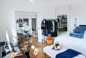 Kleiderständer, Doppelbett, Kleiderbank und Schreibtisch im Schlafzimmer