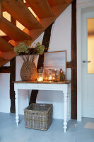 White console table, decorated with lanterns and dried flowers