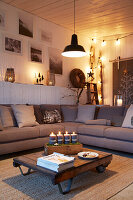 Living room with grey corner sofa, Advent candles on the coffee table and Christmas wall decorations