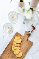 Biscuits in relief on a wooden board, two glasses of wine on a marble slab