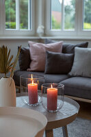 Glass lanterns with two lit candles in living room