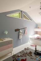 Toys on rug in child's bedroom with triangular clerestory windows