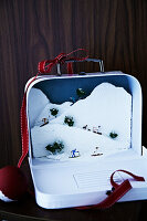 Mini winter scene crafted and arranged in a small suitcase shadow box