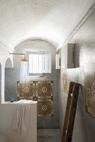 Shower area with decorative wall tiles in a simple bathroom