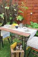 Gartentisch mit Dekos aus Birkenrinde und Holzkiste