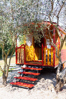 Yellow and red traditional caravan in garden