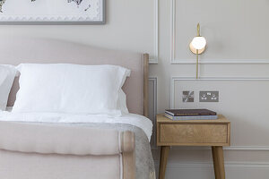 Doppelbett und Nachttisch in elegantem Schlafzimmer in Beigetönen