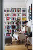Antique wingback chair in front of tall bookcase in living room