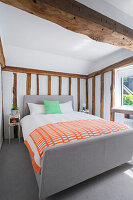 Doppelbett im Schlafzimmer mit rustikalen Holzbalken