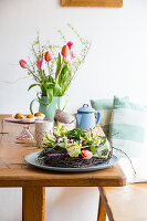 Tischkranz aus Birkenzweigen und Tulpen, im Hintergrund Tulpenstrauß in Krugvase