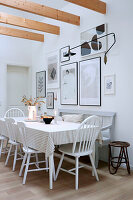 Esszimmer mit weißem Holztisch, Stühlen und moderner Wandgestaltung