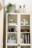 White display cabinet with books and decorative objects in a modern living ambience