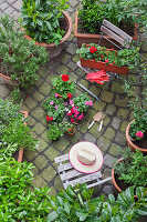 Various potted spring and summer plants ready for planting in a garden, bird's eye view
