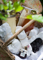 Picknickkorb mit verpackten Köstlichkeiten und Brombeeren