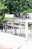 Terrassen-Sitzbereich mit weißem Tisch und Stühlen