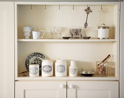 Collection of glassware and pottery on cream storage unit
