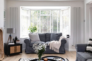 Graues Sofa im Erker eines Wohnzimmers in Reigate, Surrey, UK