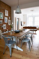 Open plan dining room with exposed brick wall in Broadstairs home, Kent, England, UK