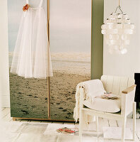 bedroom wardrobe decorated with a large print of a beach scene next to an armchair