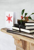 Black leather bound notebooks on mantlepiece with mistletoe