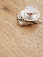 Cup and saucer with notebooks on wood