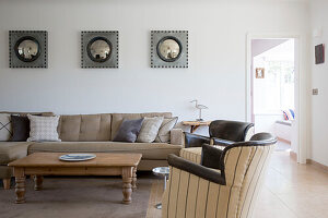 Convex mirrors above sofa with wooden coffee table in West Wittering home West Sussex England