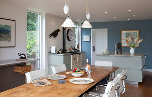 White leather chairs with pendant lights above dining table in Essex home UK