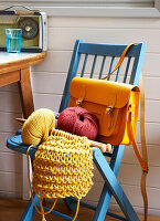 Yellow knitting with satchel on blue chair in Isle of Wight home UK