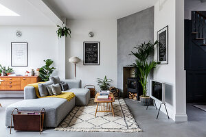 Modern living room with light grey sofa, fireplace and two-tone wall design