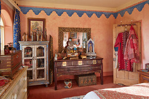 Oriental-inspired bedroom with ornate wooden furniture and colorful textiles