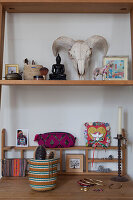 Shelf with decorative objects above wooden table with ladies' accessories