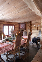 Rustic dining area in log cabin with candles and flower arrangement