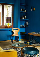 Living room with blue walls, built-in shelving and patterned carpet