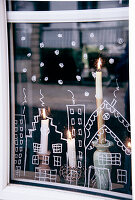 Christmas window decorations and burning candles