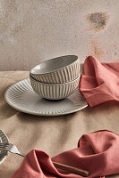 Fluted bowls and plates, pale red napkins