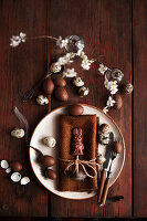 Easter place setting with brown cloth napkin, chocolate Easter bunny, chocolate eggs, and quail eggs