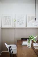 Dining area with modern artwork and bouquet of tulips on wooden table