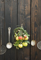Strauß aus Quitten und Äpfel an Holztür mit Küchengeräte